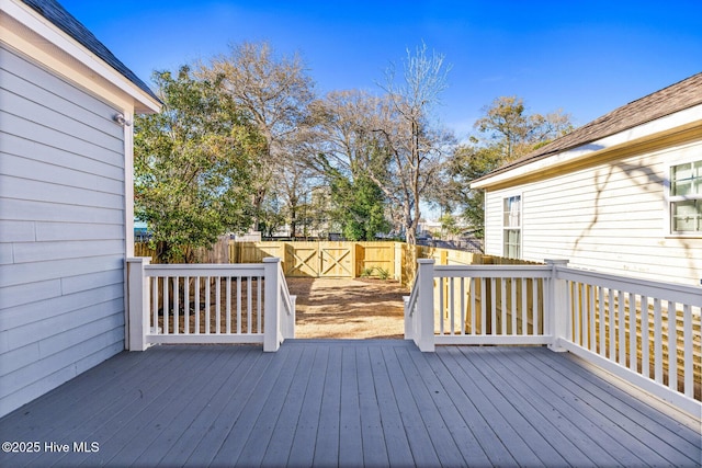 wooden terrace with a fenced backyard