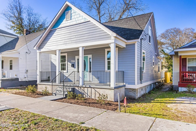 bungalow with covered porch and roof with shingles