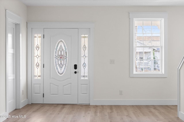 foyer with light wood-style flooring and baseboards