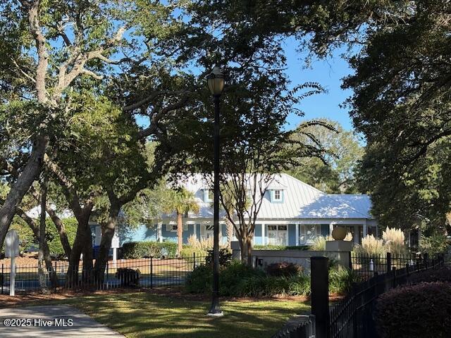 view of front of property featuring metal roof and a fenced front yard