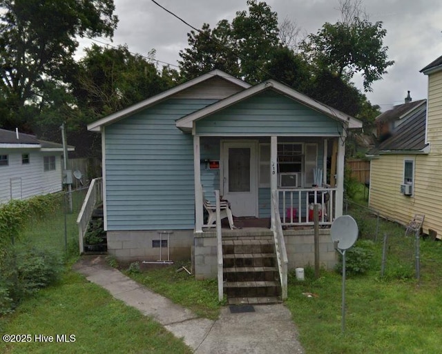 bungalow-style home featuring stairway, covered porch, and a front lawn