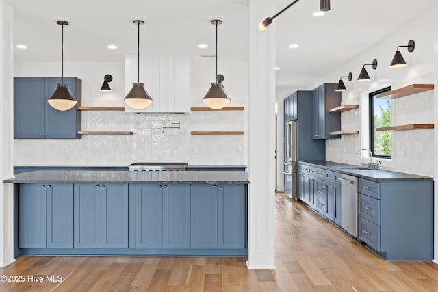 kitchen featuring light wood-style floors, stainless steel appliances, blue cabinetry, open shelves, and a sink