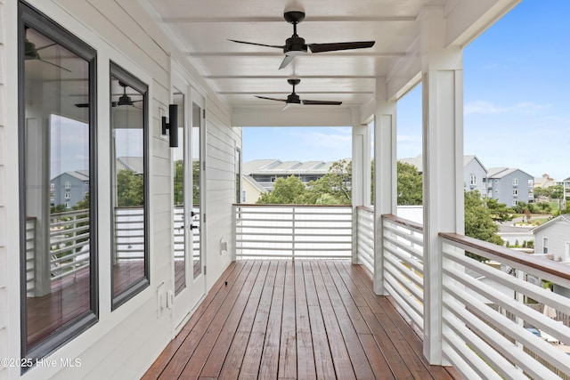 wooden terrace featuring a ceiling fan and a residential view