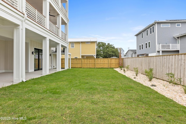 view of yard featuring a fenced backyard and a balcony