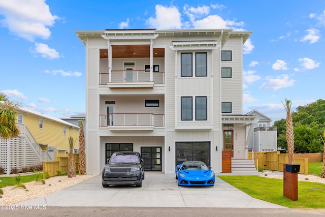 view of front facade featuring a garage, a balcony, driveway, and board and batten siding