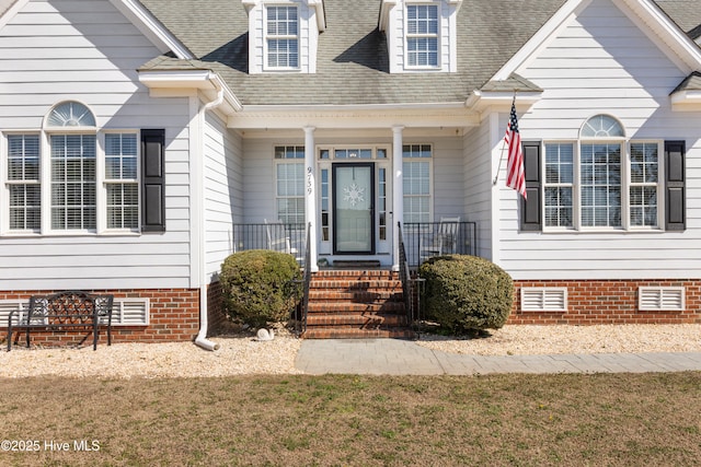 view of exterior entry with a shingled roof and crawl space