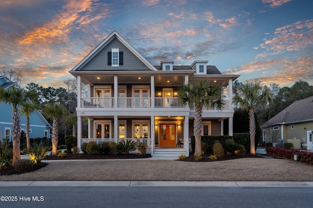 view of front facade featuring covered porch, french doors, and a balcony