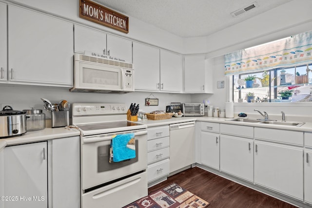 kitchen featuring light countertops, white appliances, a sink, and visible vents