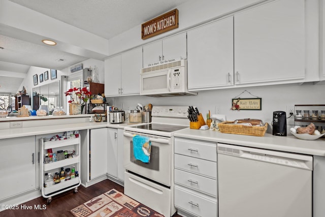 kitchen featuring light countertops, dark wood-type flooring, white cabinets, a textured ceiling, and white appliances