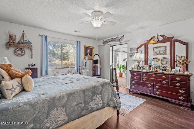 bedroom featuring a textured ceiling, ceiling fan, wood finished floors, and visible vents