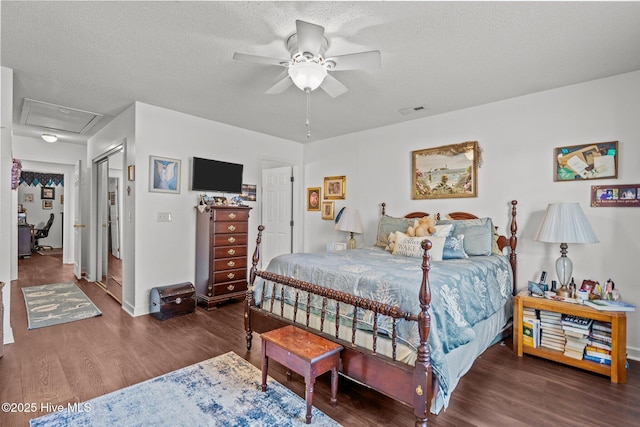 bedroom featuring attic access, baseboards, visible vents, wood finished floors, and a textured ceiling