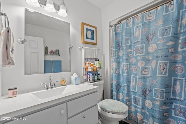 full bathroom featuring curtained shower, vanity, and toilet