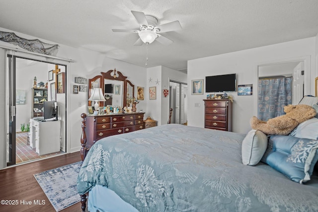 bedroom with a ceiling fan, a textured ceiling, and wood finished floors