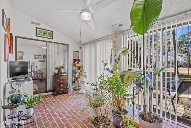 sunroom with vaulted ceiling, visible vents, and a ceiling fan