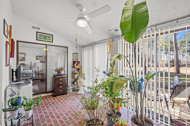 sunroom / solarium with ceiling fan, visible vents, and vaulted ceiling