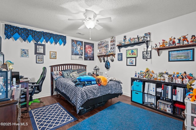 bedroom featuring a textured ceiling, wood finished floors, visible vents, and baseboards