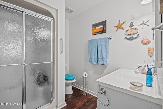 full bathroom with visible vents, a shower stall, toilet, and wood finished floors