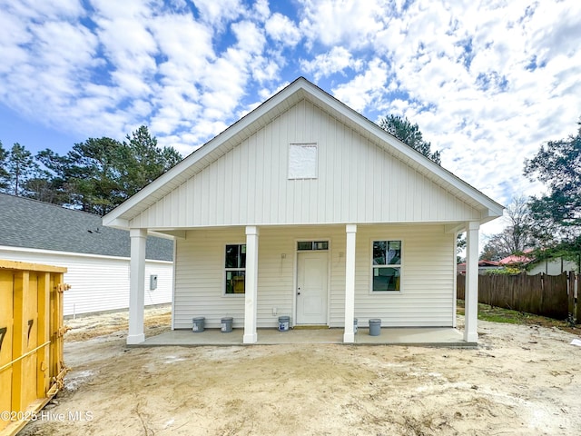 view of front facade featuring fence and covered porch