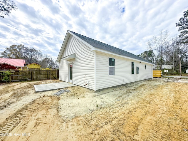 rear view of house featuring fence and a patio