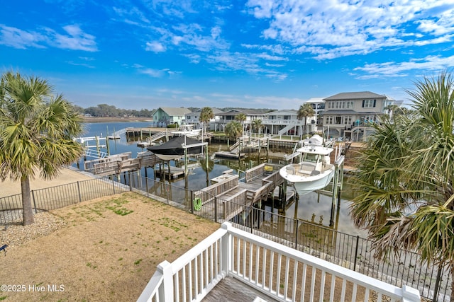 view of dock featuring a fenced backyard, a water view, boat lift, and a residential view