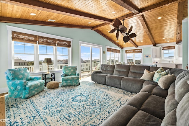 living room with vaulted ceiling with beams, wood ceiling, and a ceiling fan