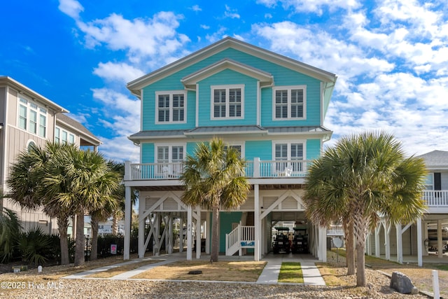 view of front of house featuring driveway, a standing seam roof, and a carport