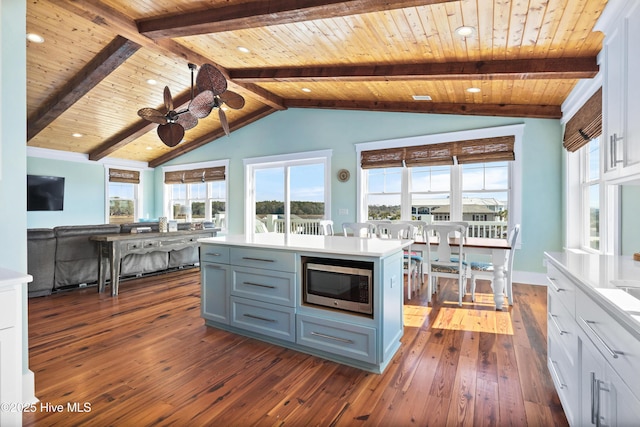 kitchen featuring light countertops, stainless steel microwave, and white cabinets