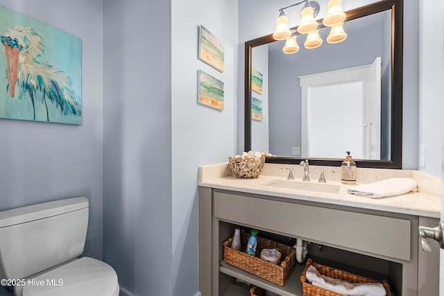 bathroom with vanity, toilet, and an inviting chandelier