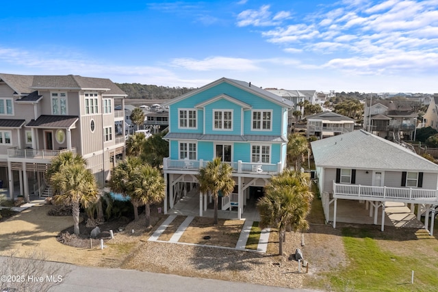 coastal home featuring metal roof, a carport, a residential view, and driveway