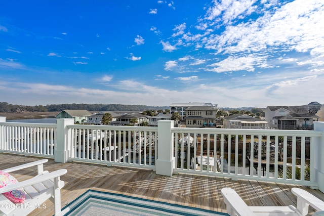 wooden terrace with a residential view and a water view