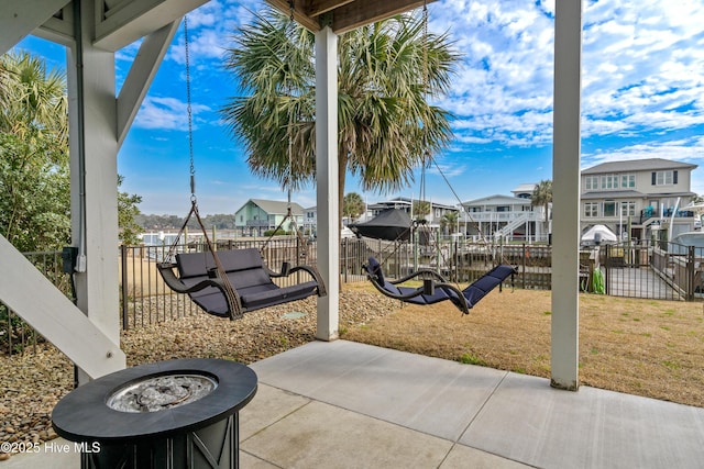 exterior space featuring a fire pit, a patio, a yard, and a residential view