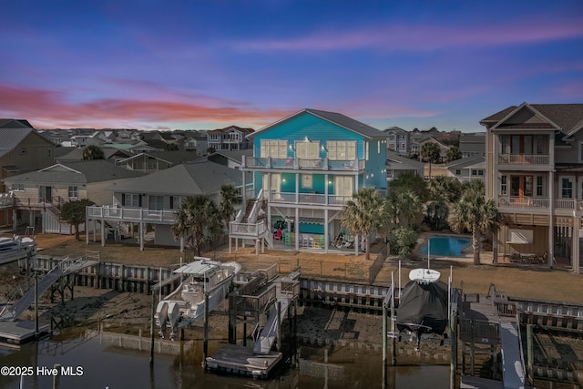 exterior space featuring a residential view, boat lift, and a balcony