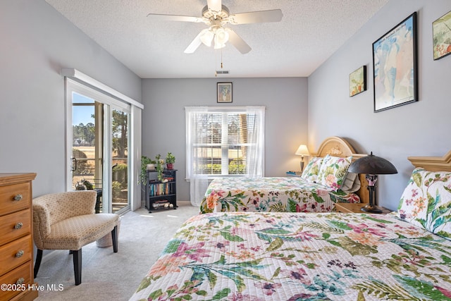 bedroom featuring access to exterior, carpet, visible vents, a ceiling fan, and a textured ceiling