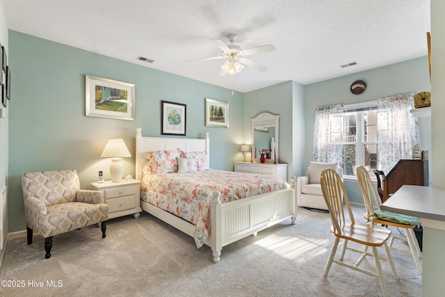 bedroom featuring visible vents, ceiling fan, light carpet, and a textured ceiling