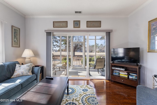 living room with crown molding, visible vents, and wood finished floors