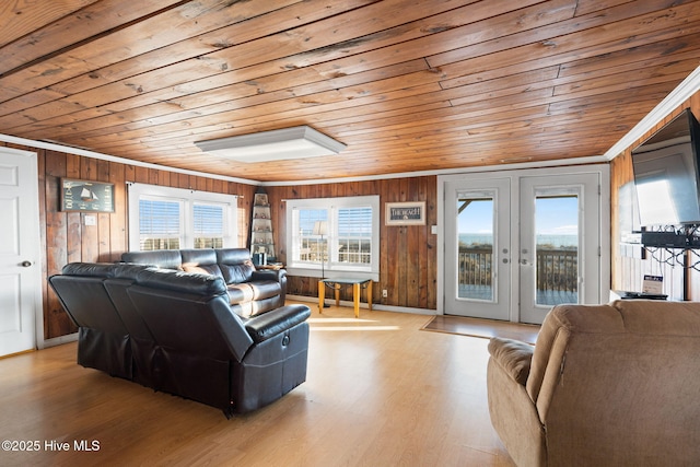 living area with light wood-style floors, wood ceiling, wood walls, and french doors