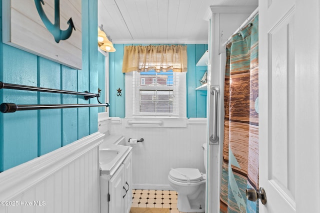 full bathroom featuring a wainscoted wall, ornamental molding, vanity, and toilet