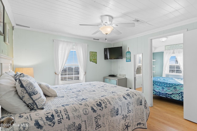 bedroom featuring ornamental molding, light wood-style floors, and ceiling fan