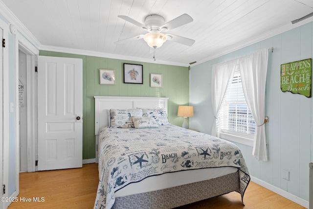 bedroom featuring ornamental molding, light wood-type flooring, baseboards, and a ceiling fan