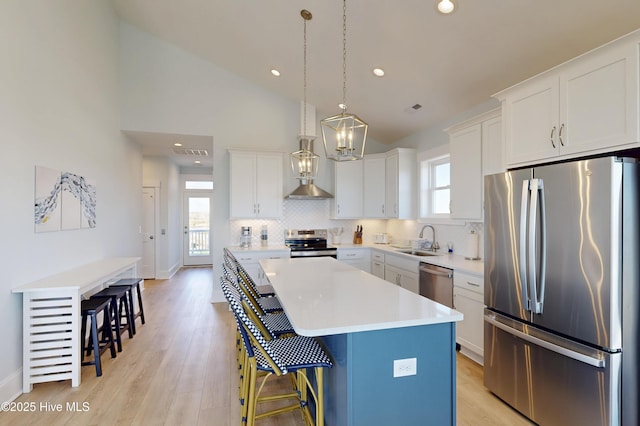 kitchen with white cabinets, stainless steel appliances, light countertops, and a center island