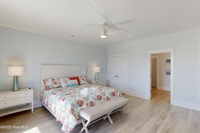 bedroom with a closet, crown molding, light wood-style flooring, and baseboards