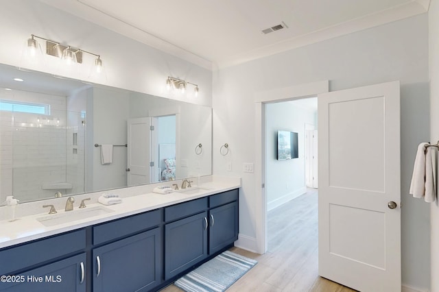 full bath with double vanity, walk in shower, a sink, and visible vents