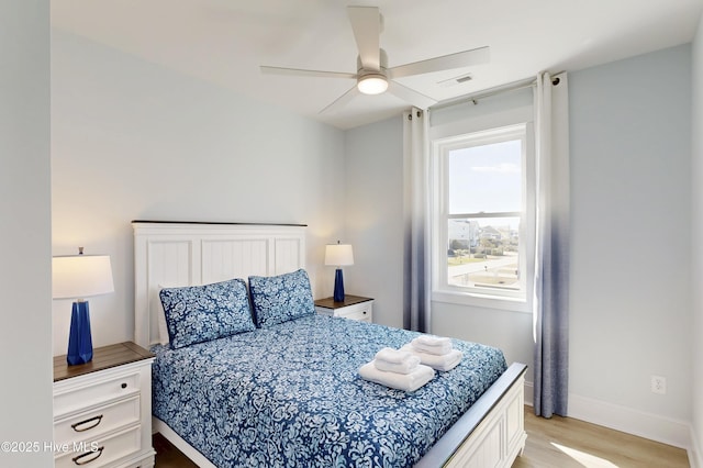 bedroom featuring a ceiling fan, baseboards, visible vents, and light wood finished floors