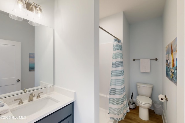 bathroom featuring vanity, curtained shower, wood finished floors, and toilet