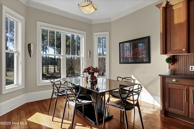dining area with dark wood-style flooring, baseboards, and ornamental molding