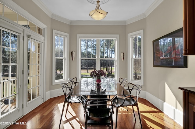 dining space with baseboards, light wood-style floors, a healthy amount of sunlight, and crown molding