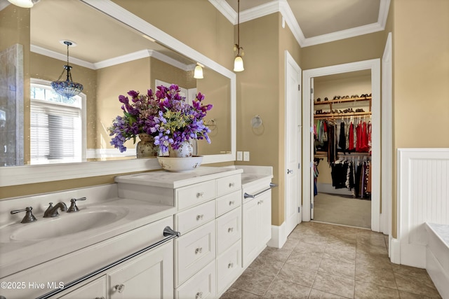 full bath with ornamental molding, a walk in closet, vanity, and tile patterned floors