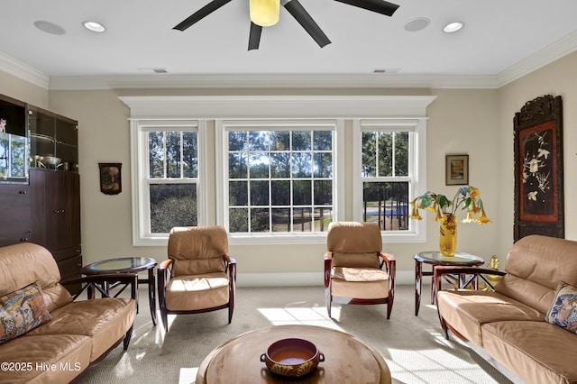 living area featuring light colored carpet, ceiling fan, ornamental molding, plenty of natural light, and recessed lighting