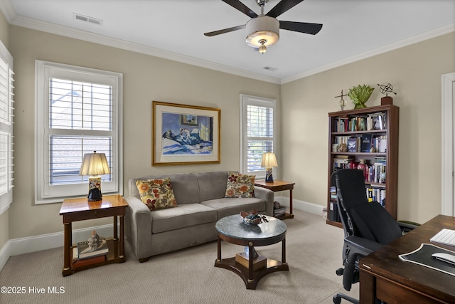 home office with light colored carpet, a ceiling fan, baseboards, visible vents, and crown molding