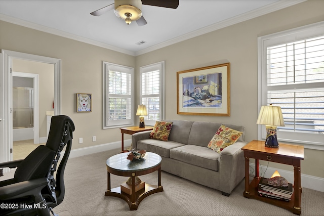 carpeted living area featuring crown molding, ceiling fan, and baseboards